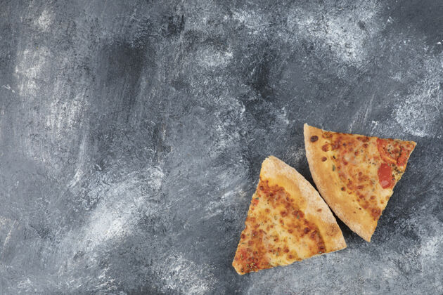 正餐两片美味的新鲜披萨放在石头背景上美味奶酪食物