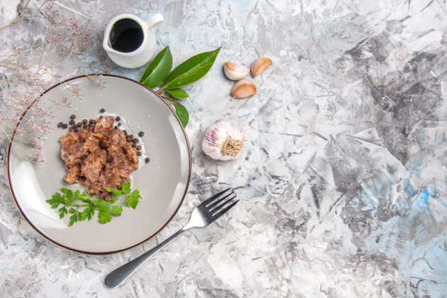 沙拉俯瞰美味的肉食与酱汁在一个浅白色的餐桌上晚餐肉菜盘子晚餐健康