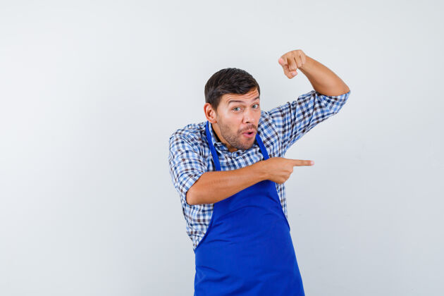年轻穿着蓝色围裙和衬衫的年轻男厨师烹饪衬衫成人