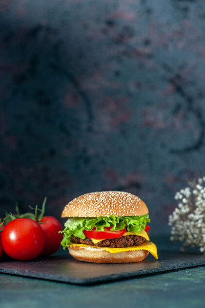 深色前视图美味的肉汉堡包与红色西红柿在黑暗的背景饮食蔬菜快餐