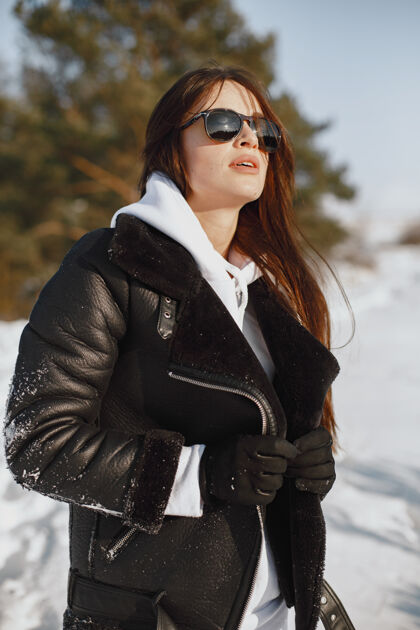 手穿黑夹克的女人的特写照片雪天站在森林里的女人成人女人行走