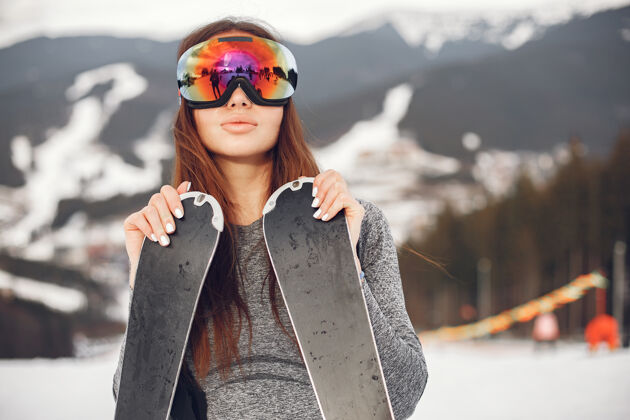 冬季年轻活跃的黑发滑雪雪山上的女人年轻女孩护目镜