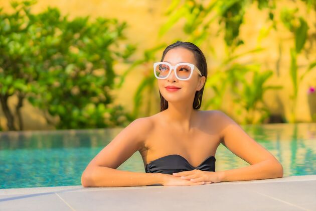 女人美丽的亚洲年轻女子在游泳池里放松的画像健康时尚热带