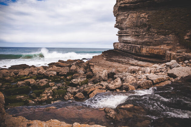 水美丽的景色在悬崖边的海岸上荡漾着波浪石头泡沫岩石