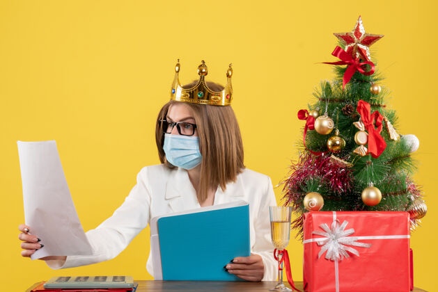 笔记本电脑前视图女医生带着文件戴着无菌口罩面具圣诞节肖像