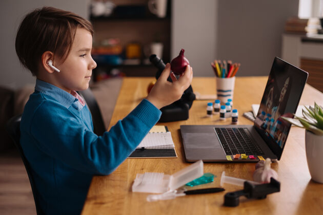 知识一个未成年男孩用笔记本电脑和他的老师打视频电话显微镜孩子教育