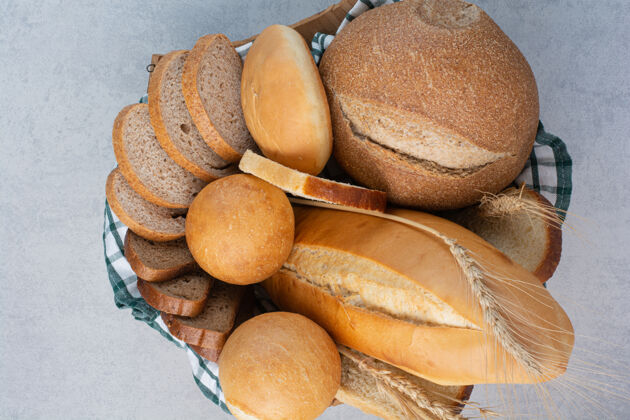法式面包香喷喷的面包放在大理石表面的篮子里食品面包房营养