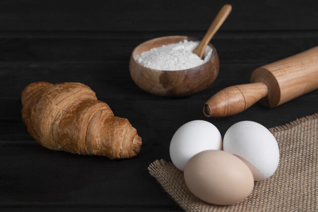 鸡蛋纯羊角面包 一碗面粉和生鸡蛋在深色的木头表面高品质的照片面包皮甜点面包