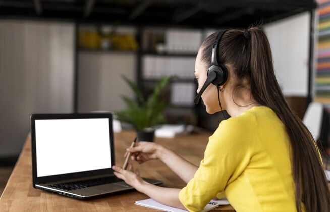 耳机工作中的肖像女性有视频通话女性视频通话办公桌