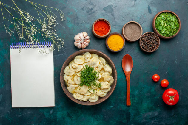汤俯瞰美味的饺子汤与绿色和不同的调味料对暗面汤面团蔬菜食品肉顶部绿色晚餐