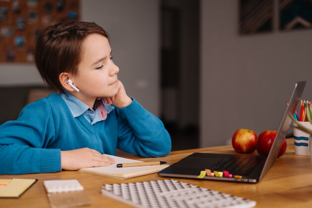 显微镜一个未成年男孩用笔记本电脑在线上课小学生学校班级
