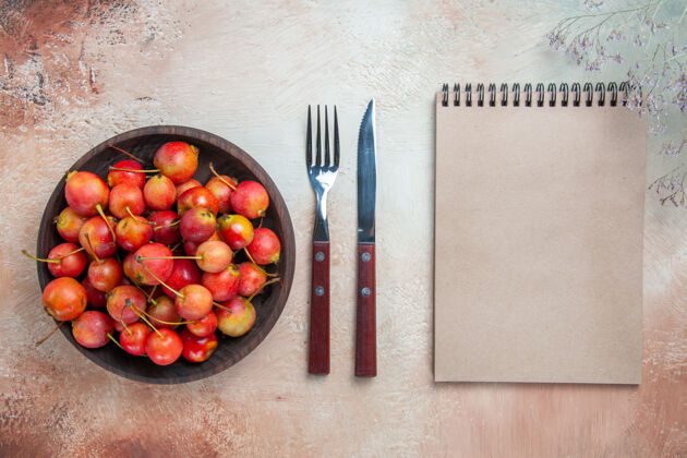 笔记本顶部特写查看樱桃开胃樱桃在碗笔记本叉刀可食用水果水果胡椒