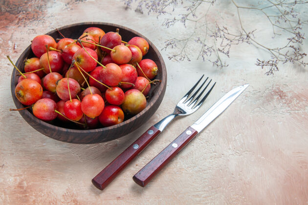 壁板侧面特写查看樱桃黄色红色樱桃在碗叉刀樱桃可食用水果营养