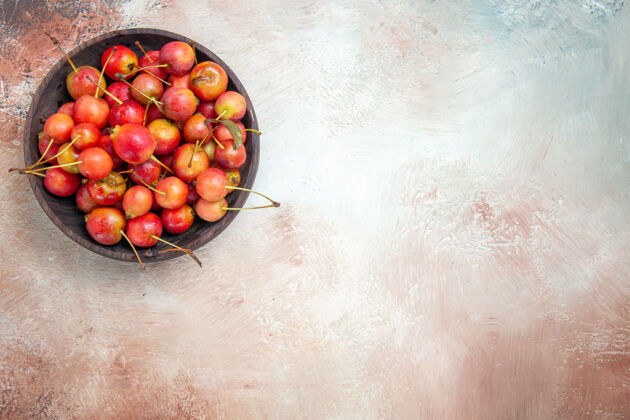 新鲜顶部特写查看樱桃一碗樱桃在粉-白-灰的桌子上农产品成熟樱桃