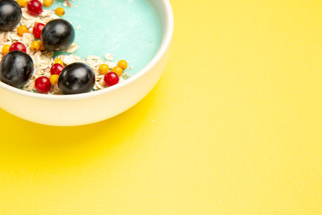 球侧特写查看浆果燕麦浆果在黄色的桌子上水果台球健康