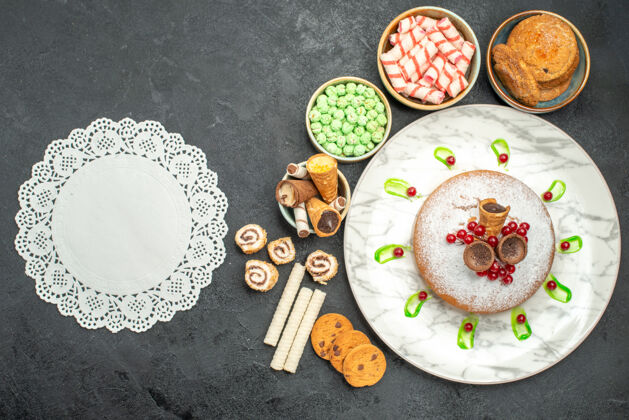 餐顶部特写镜头糖果一个蛋糕与红醋栗彩色糖果华夫饼蕾丝doily餐厅营养品盘子