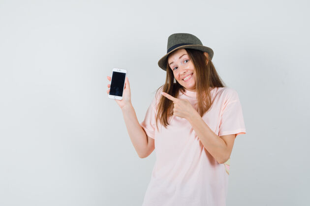 人类年轻的女士指着手机 戴着粉色的t恤帽子 看起来很可爱帽子T恤一起