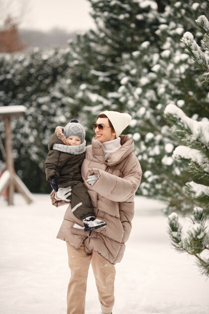 公园一家人穿着冬装在雪林里度假童年雪季节
