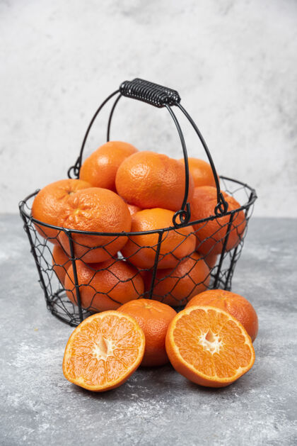 提神石桌上放着一个装满多汁橙子的金属黑色篮子柑橘异国情调热带