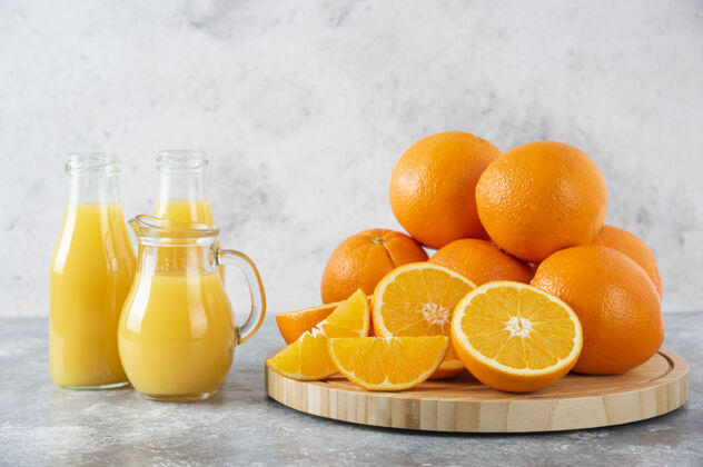 水果石桌上放着一杯果汁和新鲜的橙子新鲜美味成熟