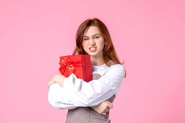 年轻女性正面图：年轻女性以红色包装呈现在粉色背景上日期：三月水平恋爱女性平等礼品礼品香水