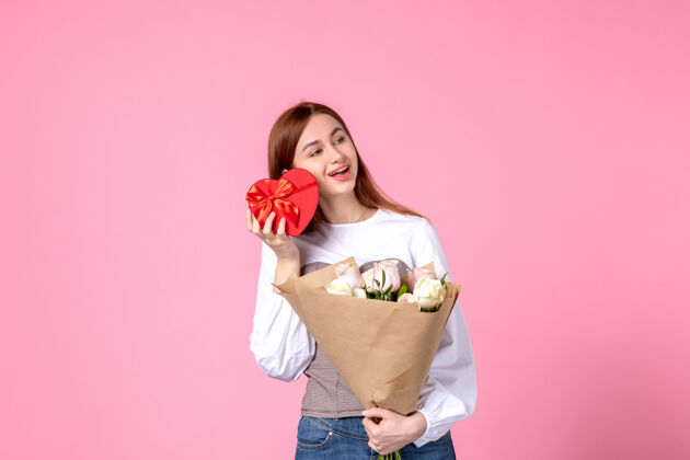 人正面图：年轻女性 带鲜花 作为女性节礼物 粉色背景 水平三月平等 性感女性约会 玫瑰女人玫瑰年轻女性礼物