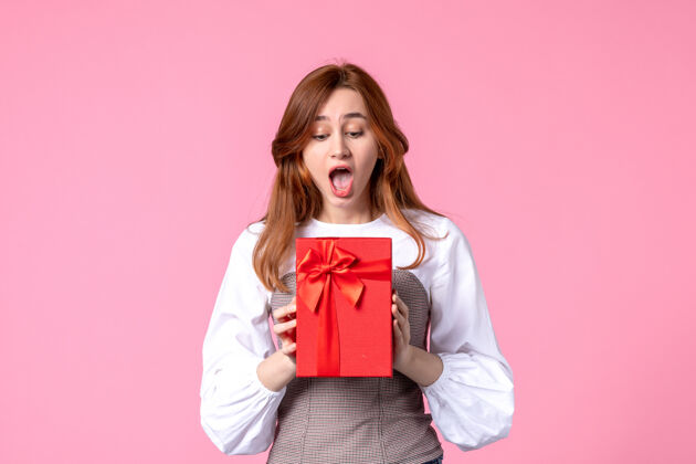 礼品正面图：年轻女性 粉色背景 红色包装 三月横向性感礼品 照片 金钱平等 女性香水包装年轻女性礼品