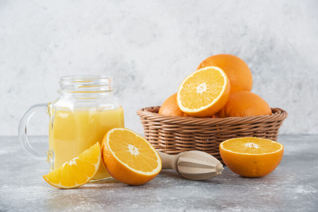 味道石桌上放着一杯果汁和新鲜的橙子成熟多汁果汁