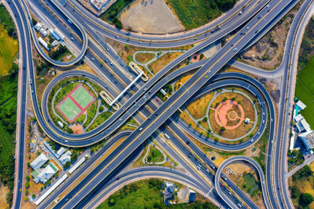 城市在巨大的公路交叉口鸟瞰交通曲线路线基础设施