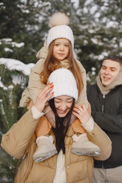 父母一家人在度假时戴着编织的冬帽家庭寒冷女儿