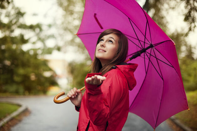 天气美丽的女人带着雨伞检查雨水保护无忧无虑气象