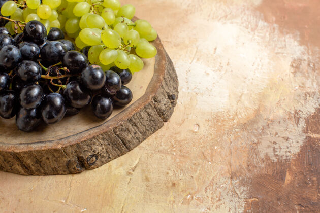 串侧面特写查看黑葡萄和绿葡萄在木板上酒精健康多汁