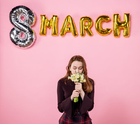 8正面图：手拿鲜花的年轻女性 粉色背景上的三月装饰呈现妇女节三月结婚激情派对性感三月8妇女节