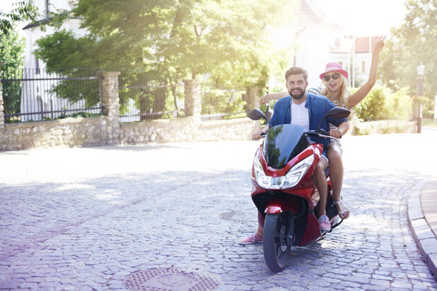 乐趣情侣骑摩托车阳光老城城市街道