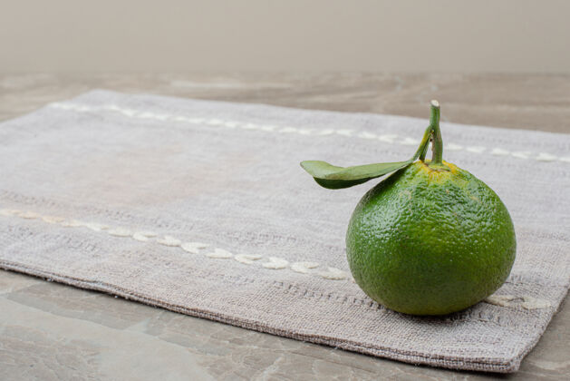 成熟一个新鲜的橘子放在灰色桌布上柑橘新鲜桌布