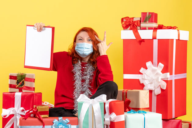 病毒前视图年轻女子围坐在圣诞礼物与文件上的黄色笔记购物服装周围