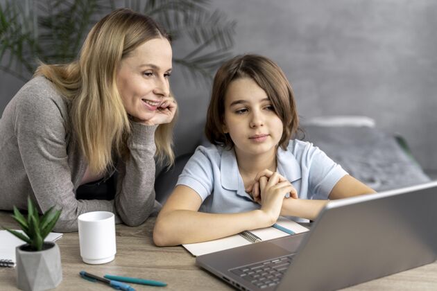 女人妈妈帮助女儿学习笔记本电脑教育技术