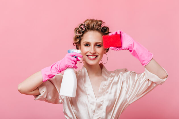 欢呼积极的女人拿着卷发器拿着洗碗用的海绵和镜子清洁器年轻人肖像