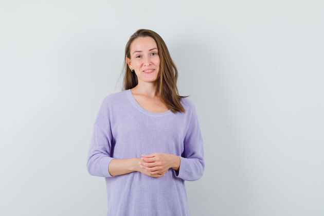 头发年轻女子站在一边微笑 身穿淡紫色上衣 看上去很积极积极衬衫女士