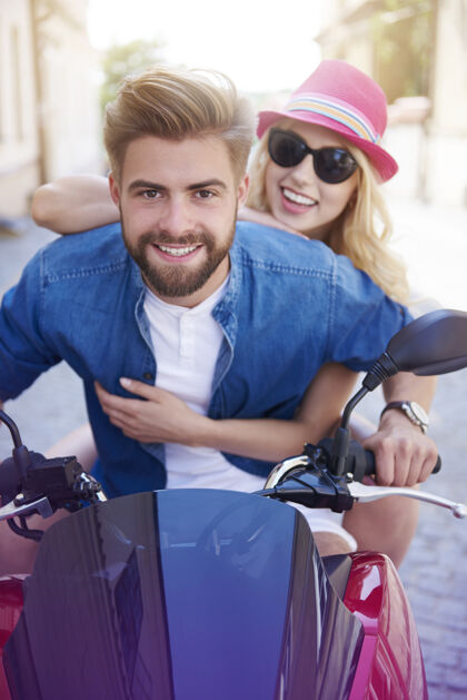休闲服骑摩托车的年轻夫妇男朋友欢乐继续