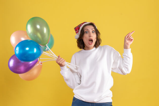 气球正面图：手持黄色气球的年轻女子年轻女人打击乐器前面