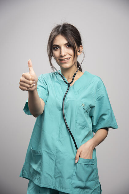 成人女医生用听诊器向格雷竖起大拇指肖像健康工作