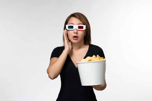 电影正面图年轻女性戴着d型太阳镜拿着薯片 在白色表面看电影电影土豆电影院