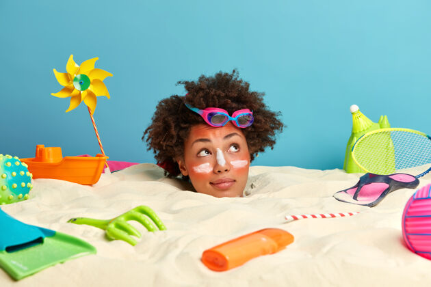 女性年轻女子头上涂着防晒霜 脸上围着沙滩饰品度假配件玩具