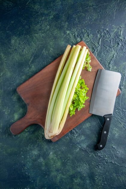 沙拉顶视图新鲜的绿色芹菜用大刀放在深蓝色表面沙拉健康饮食食品餐色照片蔬菜绿色大
