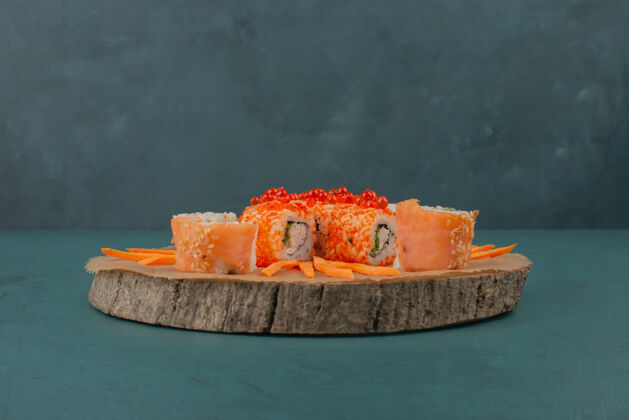 食物把寿司和胡萝卜片放在木板上搅拌混合鱼海鲜