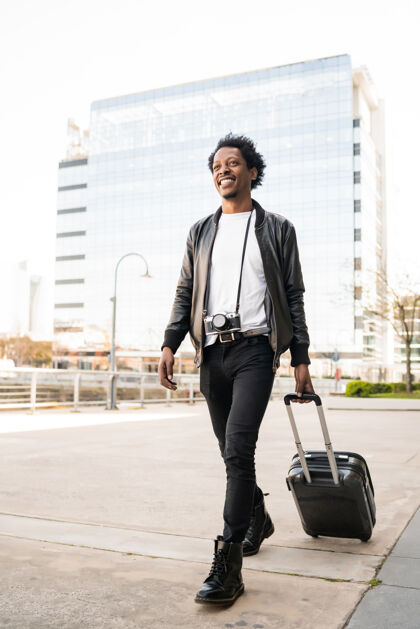 城市非洲游客在街上提着手提箱在户外行走的肖像旅游理念度假户外旅行