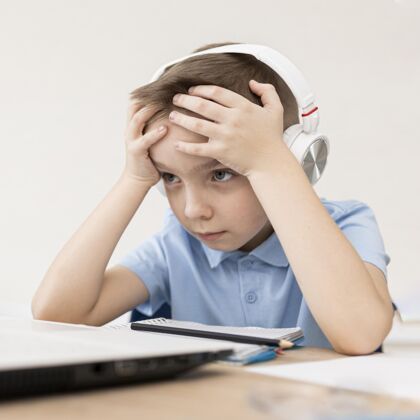 笔记本电脑戴着耳机的中枪疲倦的孩子在家耳机儿童