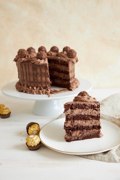 派一个巧克力蛋糕的垂直镜头和一些巧克力片旁边的盘子上的一片生日美食盘子