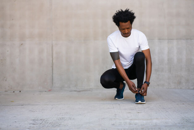运动员一个非洲裔运动员 系鞋带 准备在户外锻炼运动和健康的生活方式理念准备运动员健康